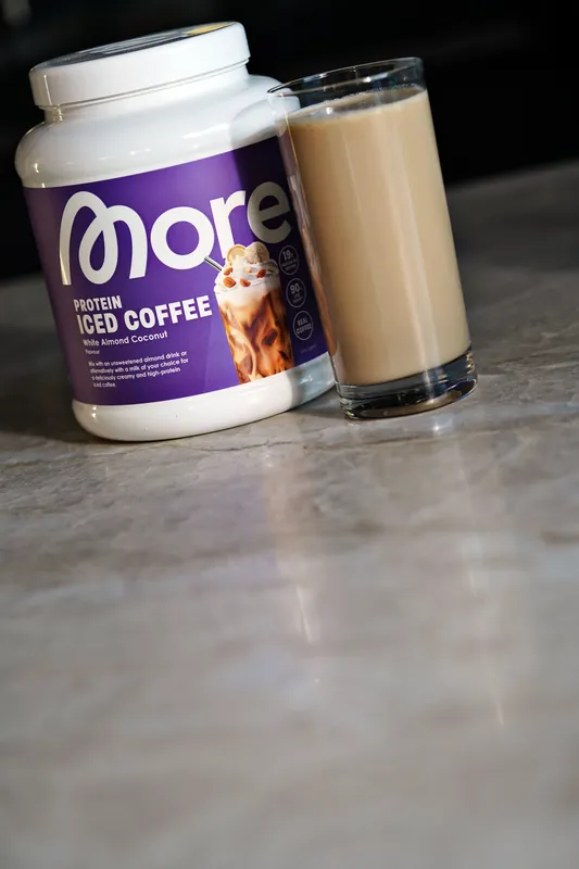 More Protein Iced Coffee – White Almond Coconut, con un vaso
